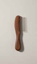 A Whisker & Wag espresso fur comb centered on a clean, neutral Soft Stone background. The comb is perfectly illuminated...
